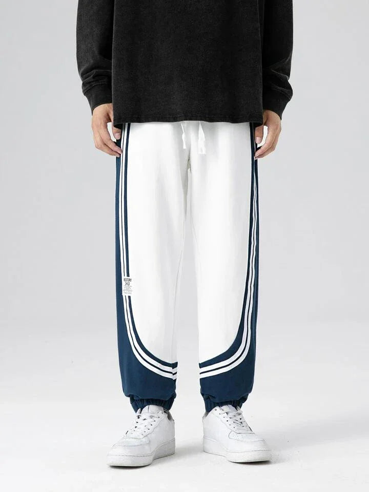 Dual-tone retro striped joggers with white and navy color block design, elastic cuffs