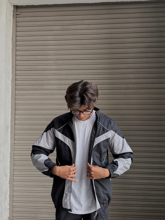 Flash photography highlighting the reactive panels on the lightweight streetwear windbreaker.