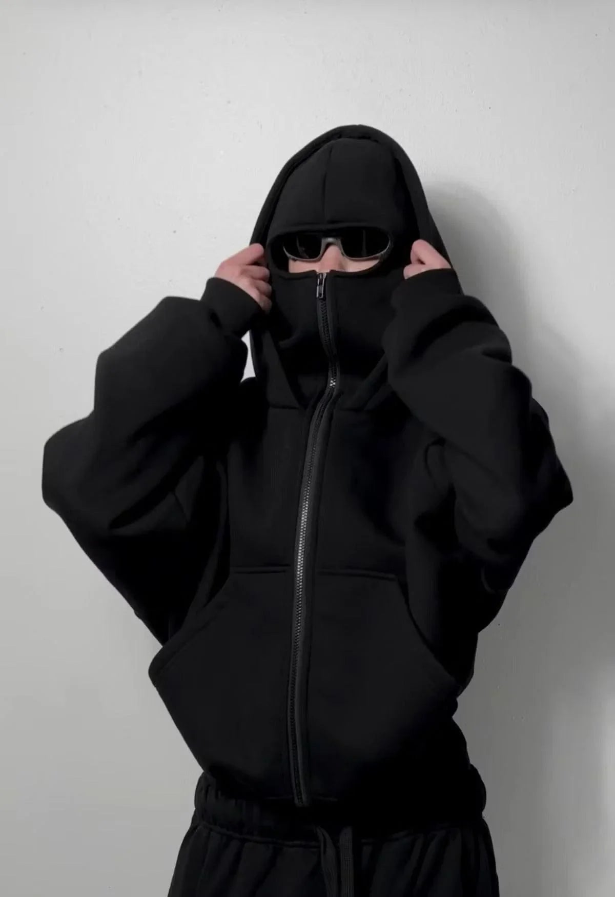 Urban streetwear oversized black hoodie with front zip, face covering, and sunglasses