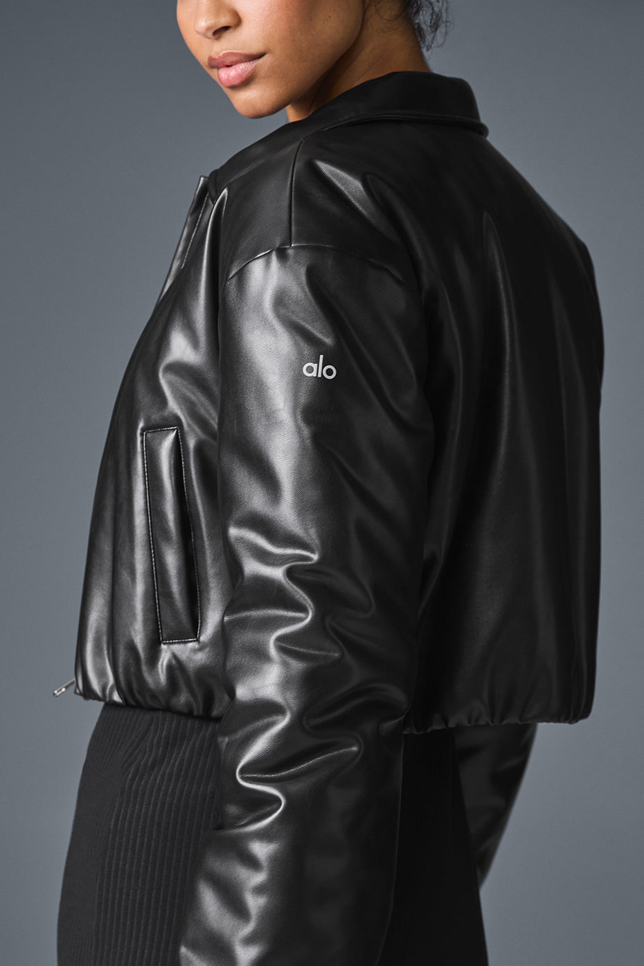 Side profile of Suspended Clothing black cropped leather jacket showing sleeve and waist fit