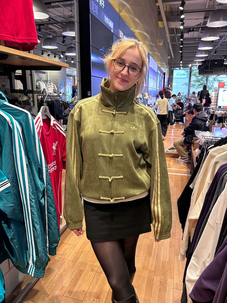 Streetwear model styling the Suspended Clothing olive green CNY edition jacket with beige cargo pants
