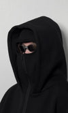 Person wearing black balaclava hoodie with integrated mask, sunglasses, and heavyweight fleece.