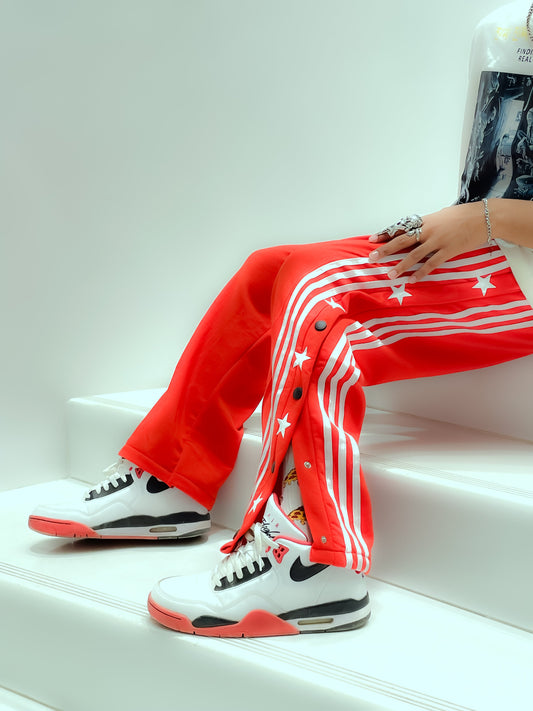 Suspended Clothing retro snap button track pants with white side stripes in a 90s breakaway style.
