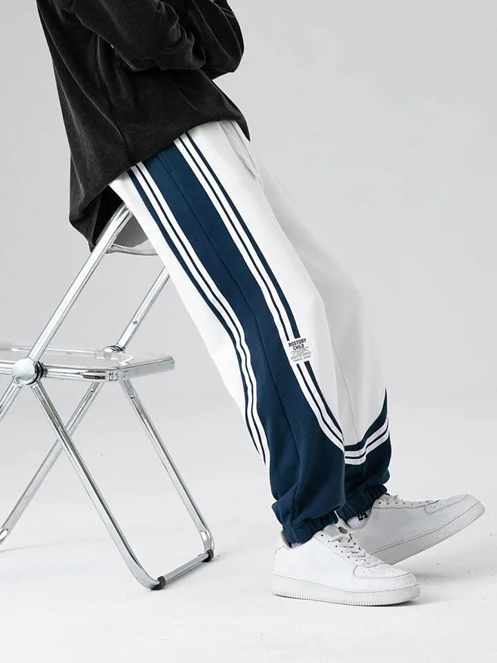 Dual-tone retro striped joggers in navy and white with side stripes, casual streetwear style