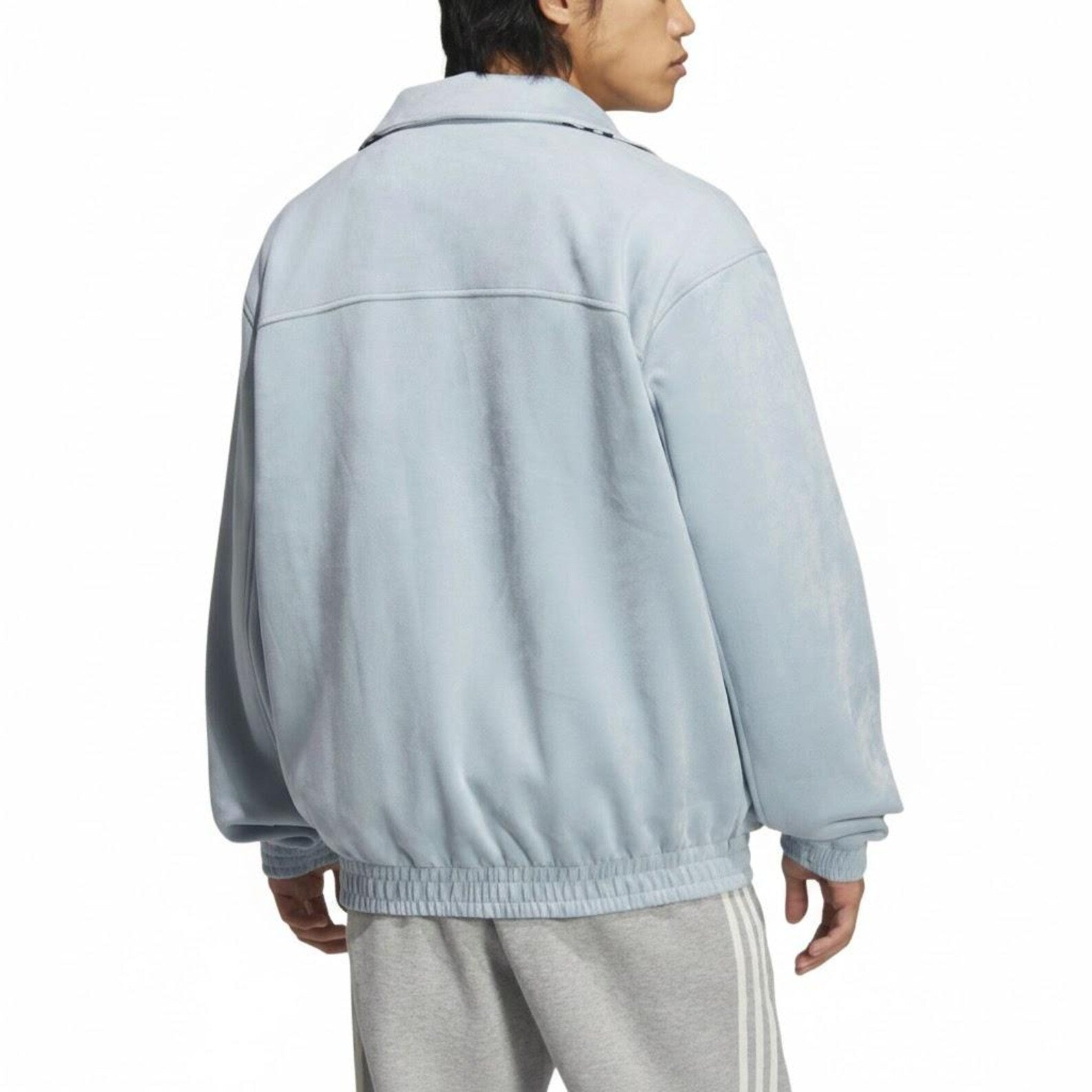 Person wearing a light aqua blue cny jacket on a white background
