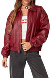 Woman wearing a red and burgundy faux leather bomber jacket with tonal color-blocking.