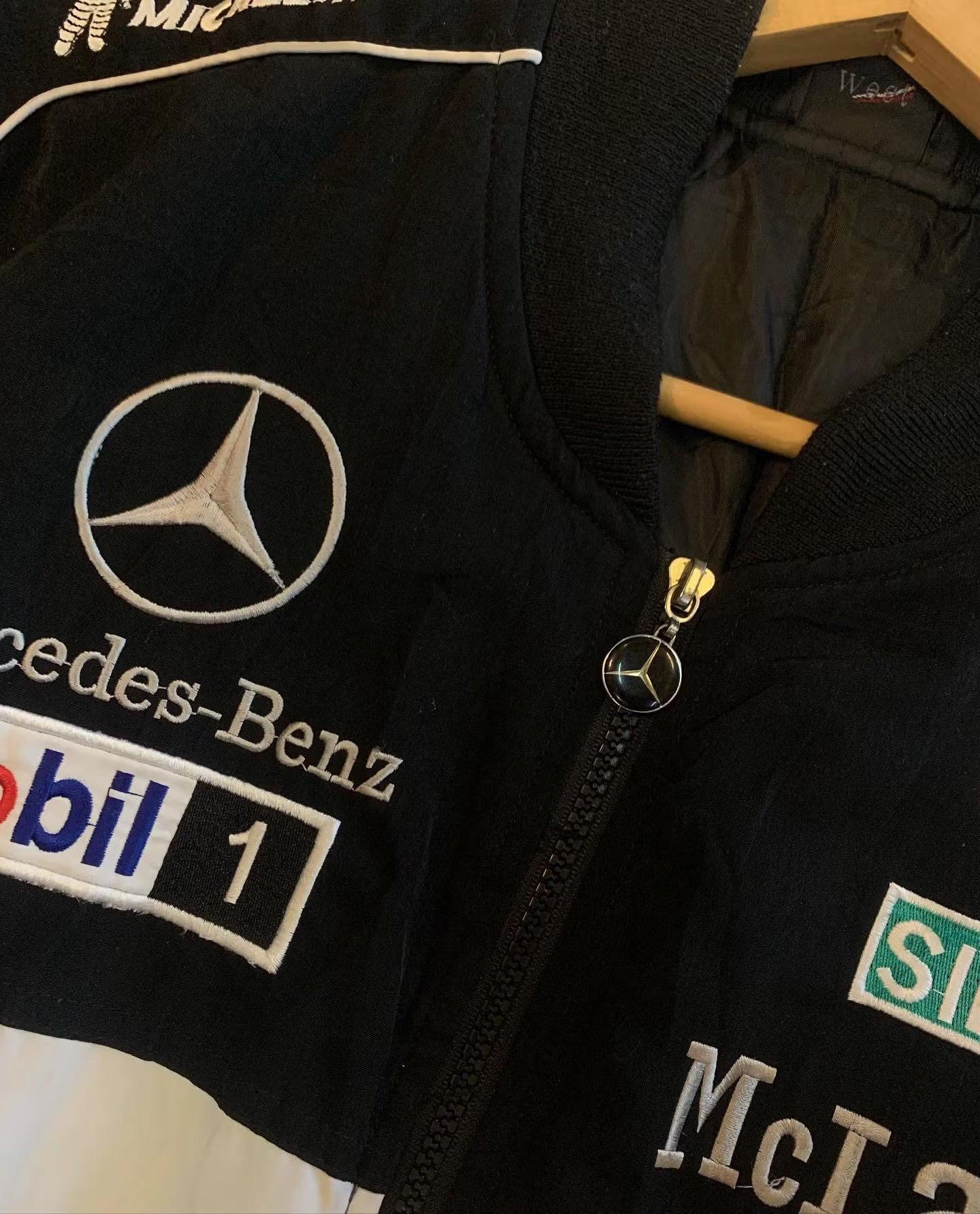 Close-up of a black vintage racing jacket with Mercedes-Benz and McLaren embroidered logos.
